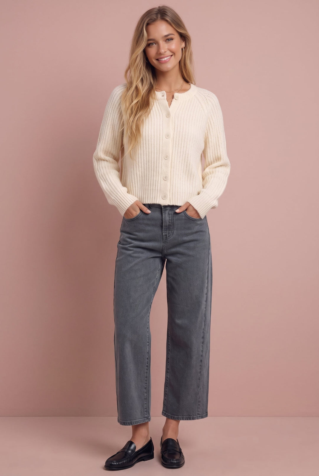Woman wearing cream ribbed cardigan and gray straight-leg jeans with black loafers, front view.