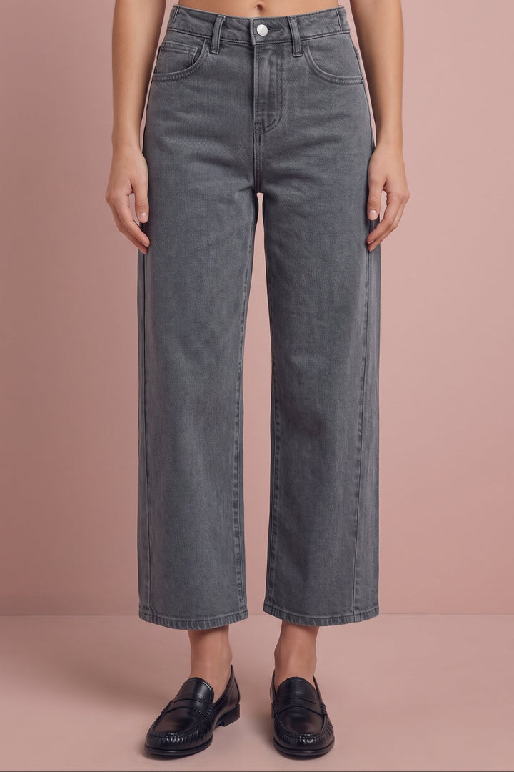 Gray cropped wide-leg jeans with white button, shown on model wearing black loafers.