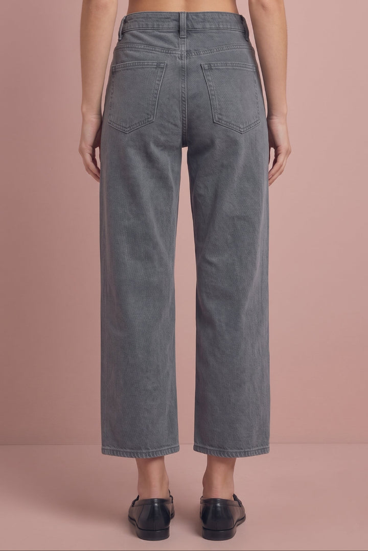 Gray cropped wide-leg jeans, back view, on model wearing black loafers.