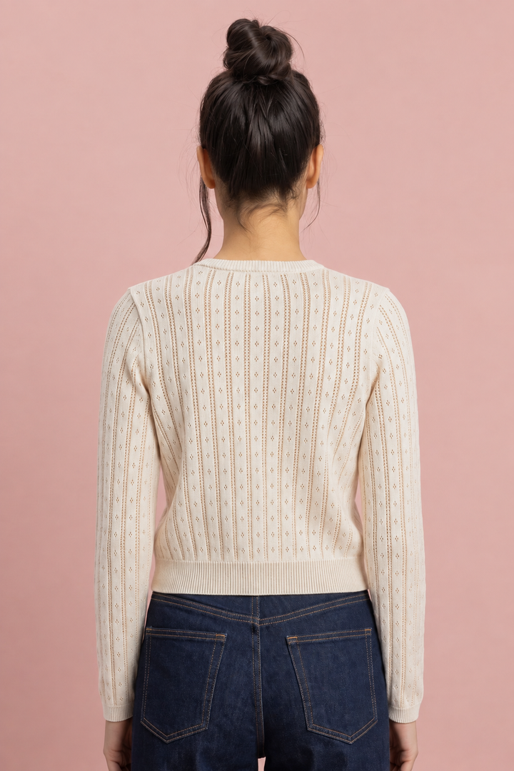 Cream pointelle knit cardigan with diamond pattern, back view, worn with dark jeans.