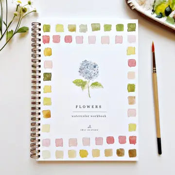 Spiral-bound workbook titled "Flowers" featuring a watercolor flower illustration surrounded by sample color palettes and brushes.