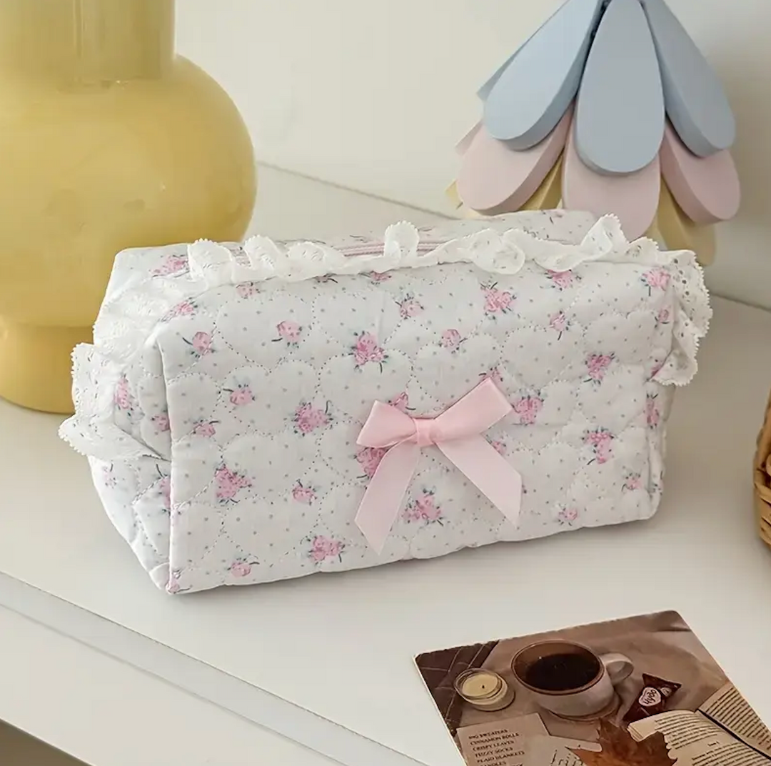 Soft gray floral print pouch with delicate lace trim and pink bow accent.