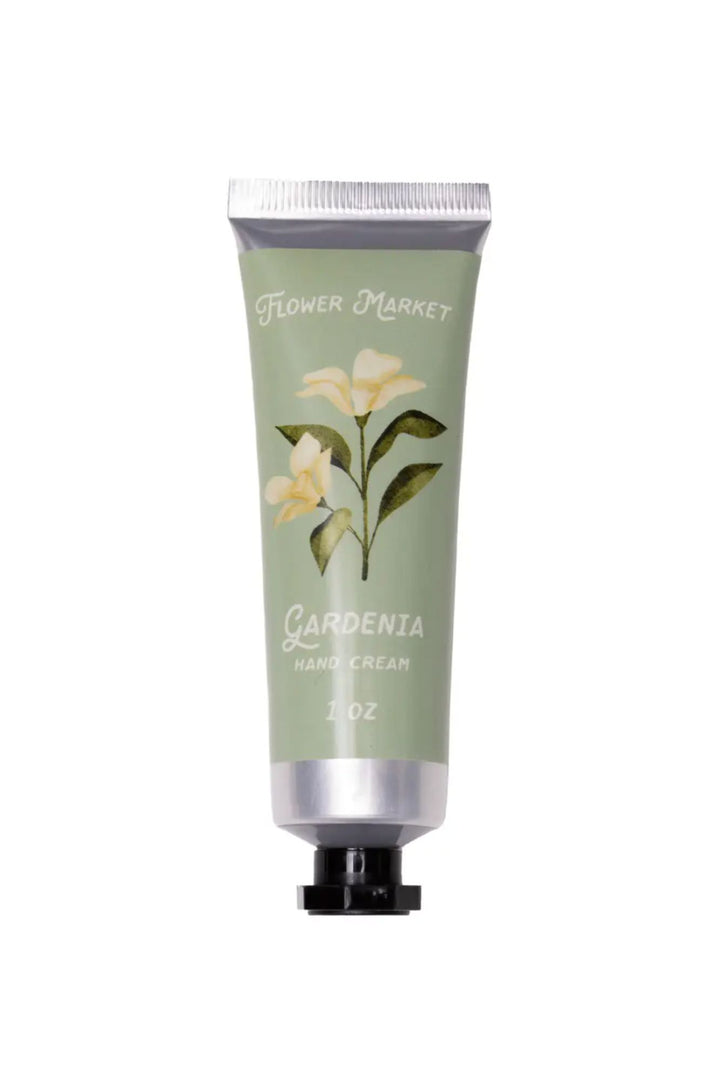 A green and white tube of Flower Market Gardenia Hand Cream, featuring a floral illustration and text describing the 1 oz size and moisturizing formula.
