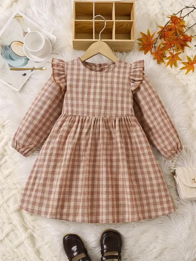 A rustic plaid girls' dress with ruffled long sleeves, a gathered waistline, and a floaty, A-line silhouette, in a warm autumnal color palette.