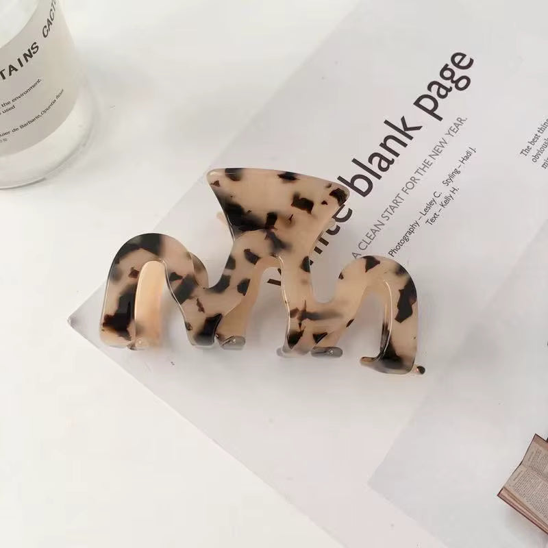 Three tortoiseshell-patterned hair claw clips in varying sizes against a white background.