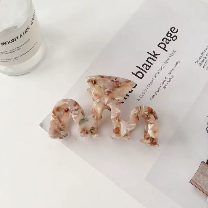 Product photo showing four acrylic hair clips in a light brown swirl pattern design.