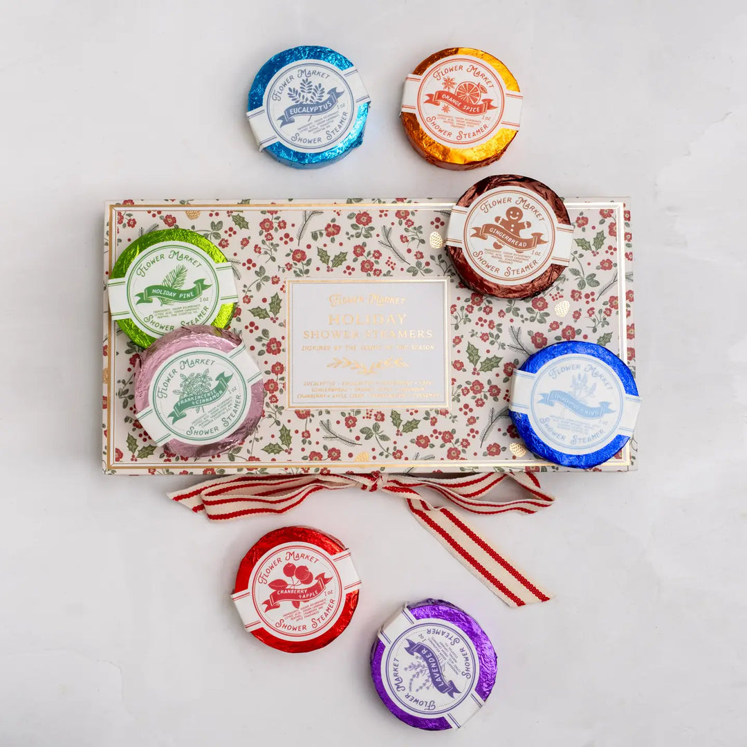 Boxed set of 8 aromatherapy shower steamers in festive floral packaging, with a variety of colorful scent discs.