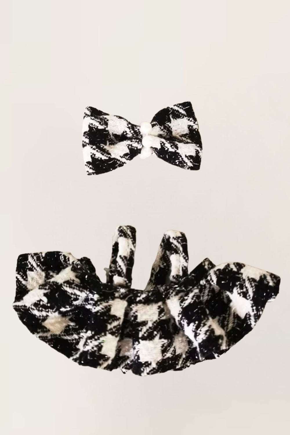 Black and white patterned bow tie and matching top on a beige background