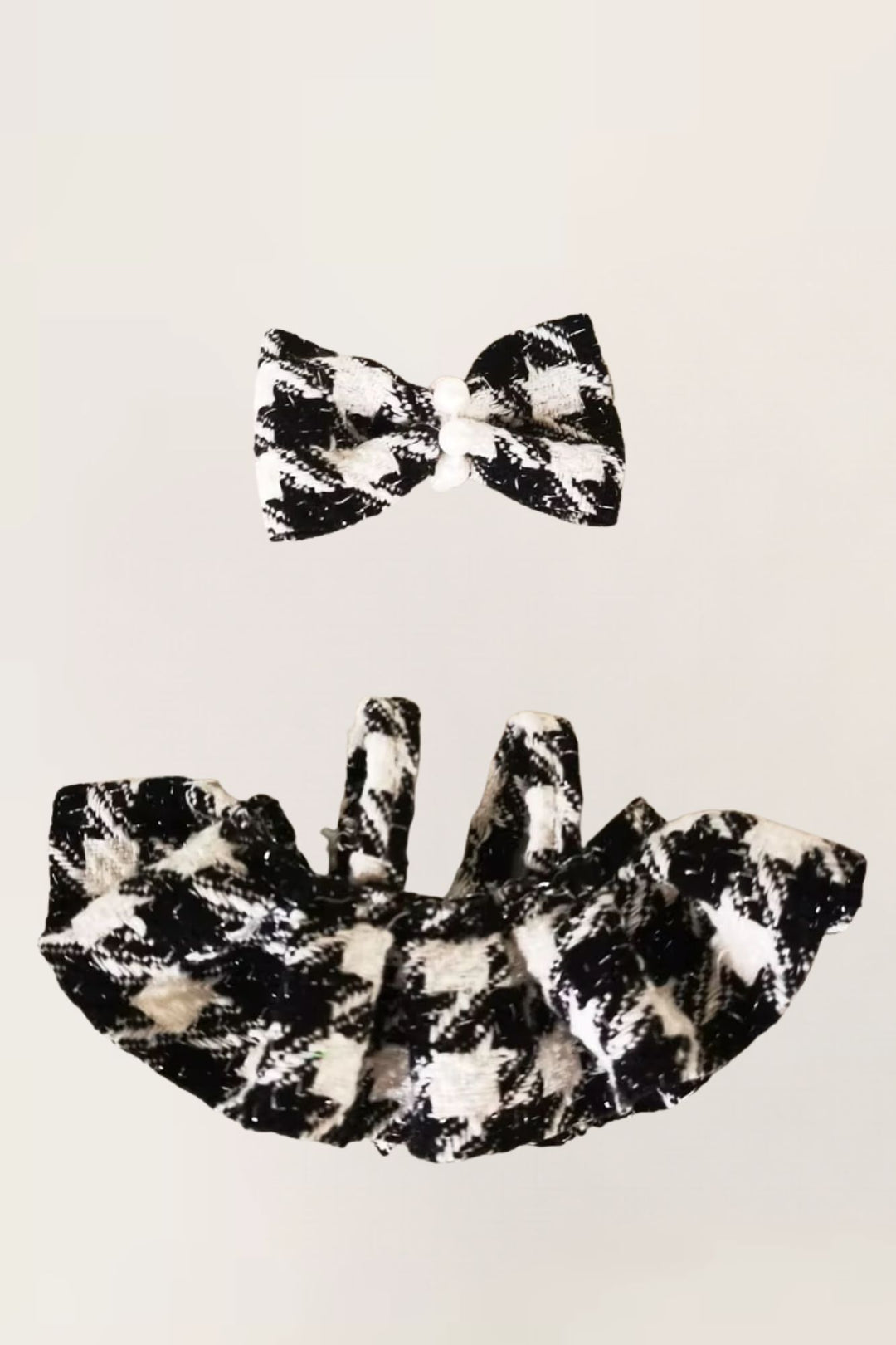 Black and white patterned bow tie and matching top on a beige background