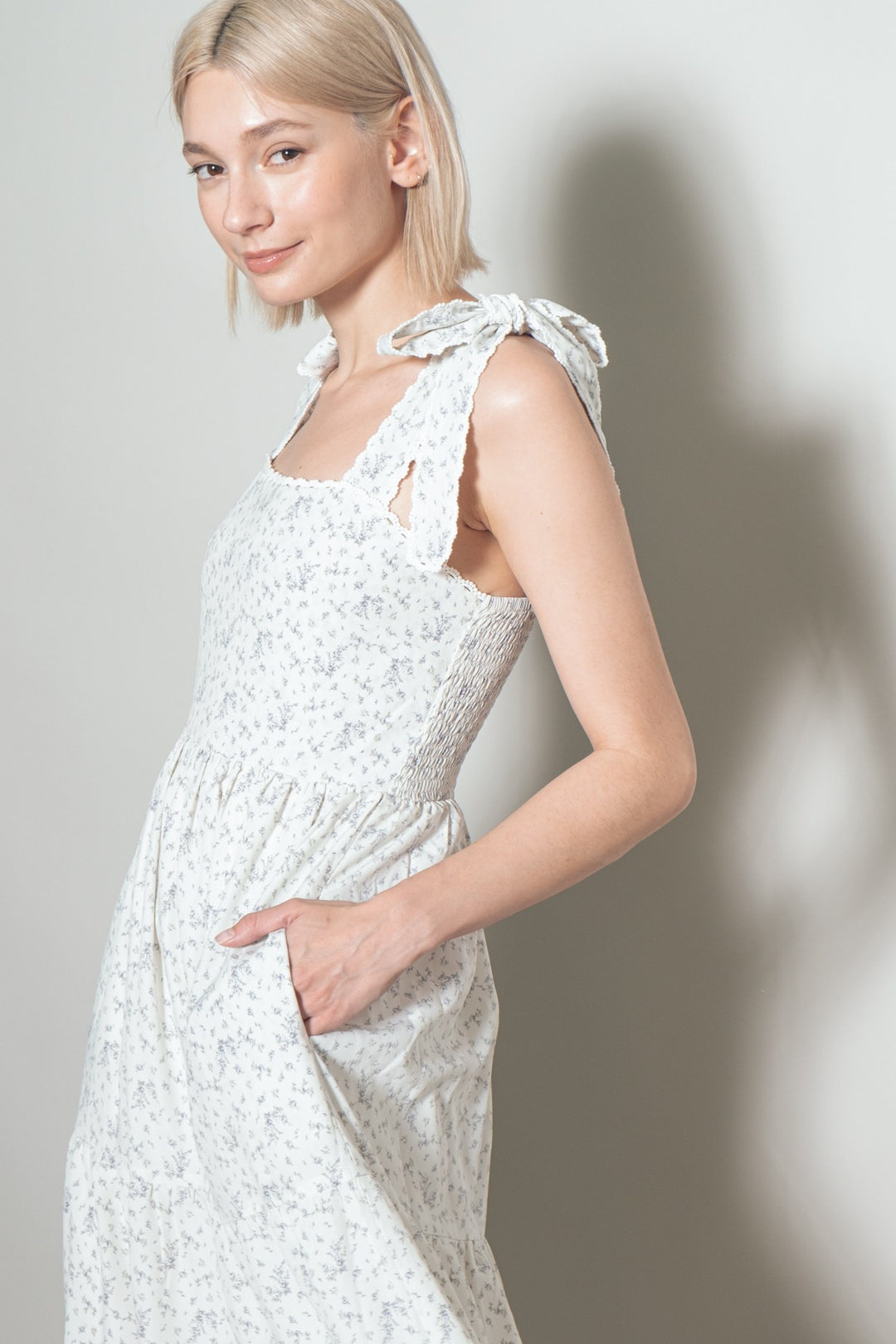 Woman wearing a white lace dress against a plain background