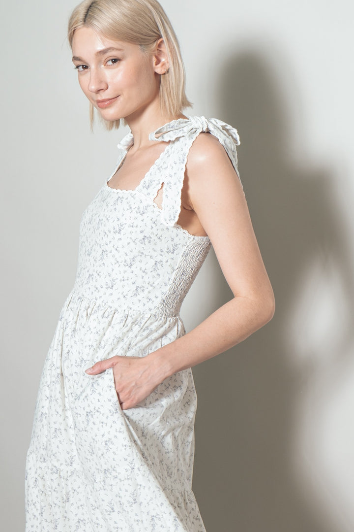 Woman wearing a white lace dress against a plain background