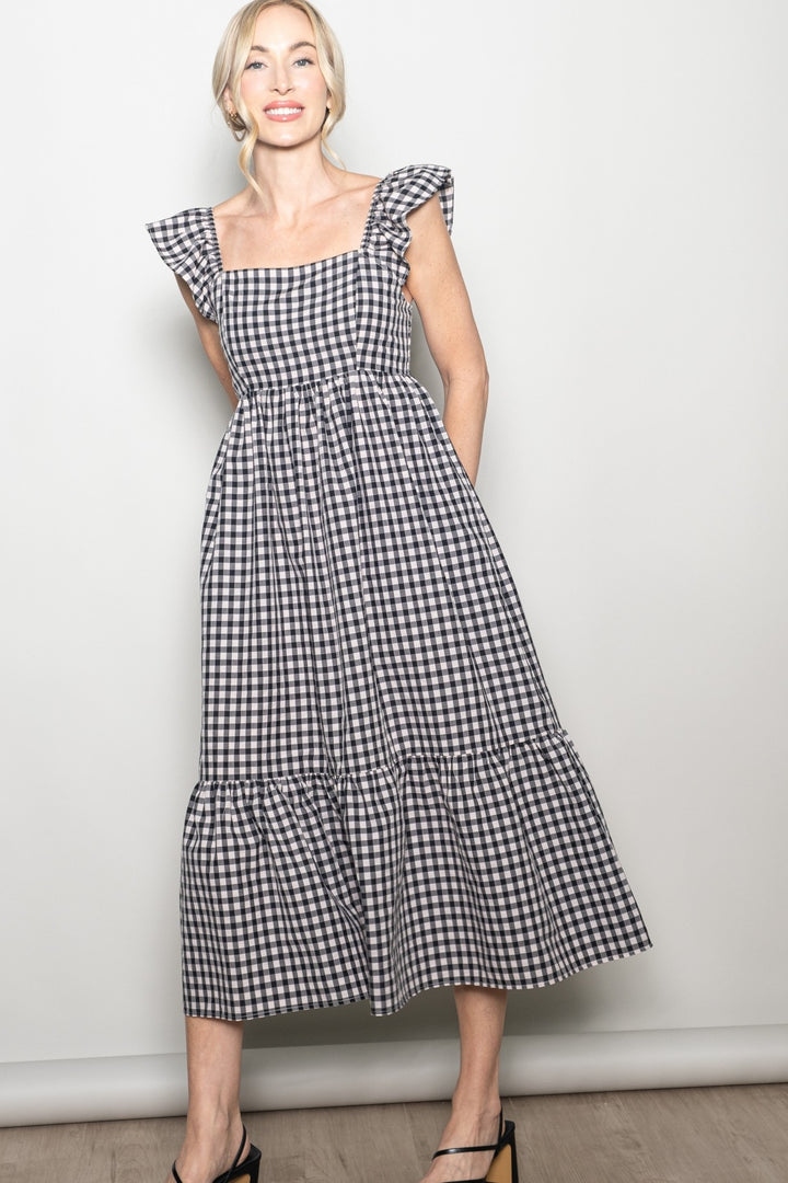 Woman wearing a black and white checkered dress against a plain background
