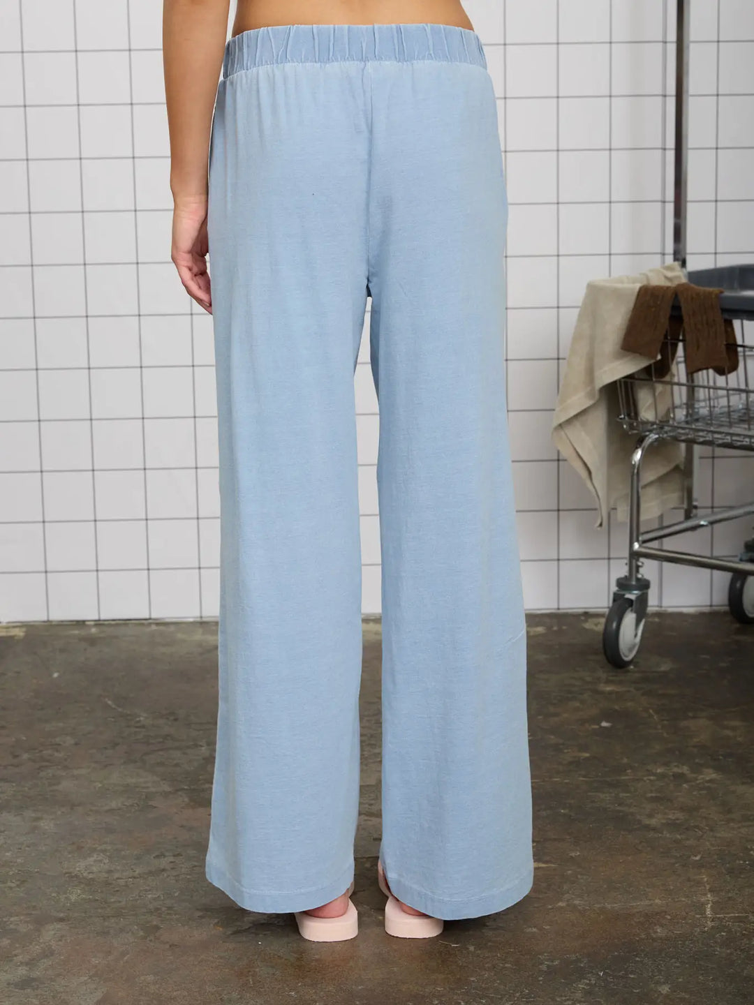 A pair of light blue, wide-leg knit lounge pants with an elastic waistband, providing a comfortable and relaxed fit.