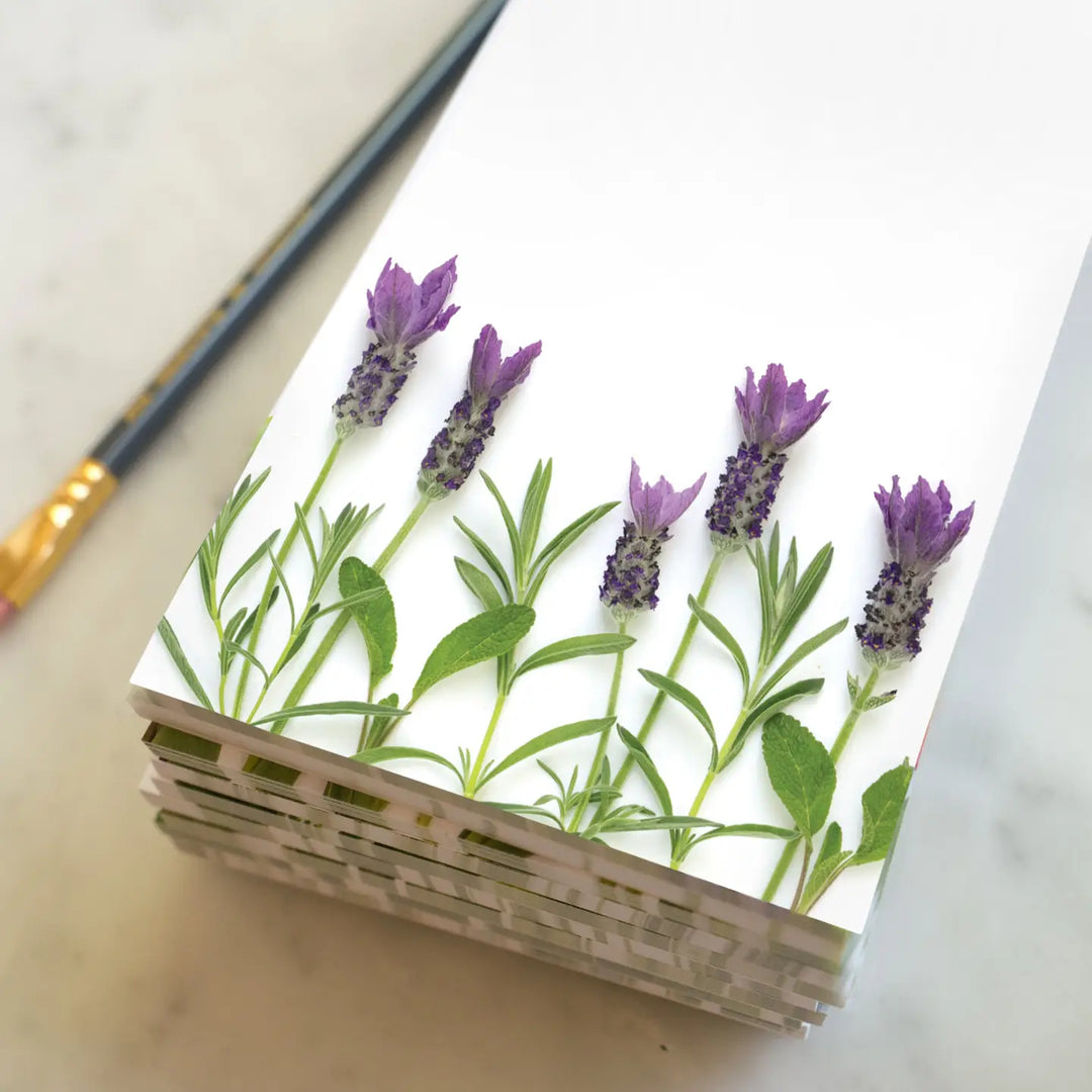 Lavender sprigs in a minimalist botanical design on a stack of elegant, recycled-paper notepads.