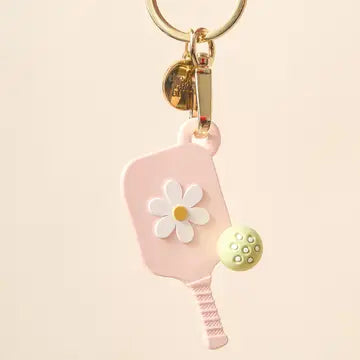 Blush pink pickleball paddle-shaped keychain with yellow daisy and green polka dot embellishments.