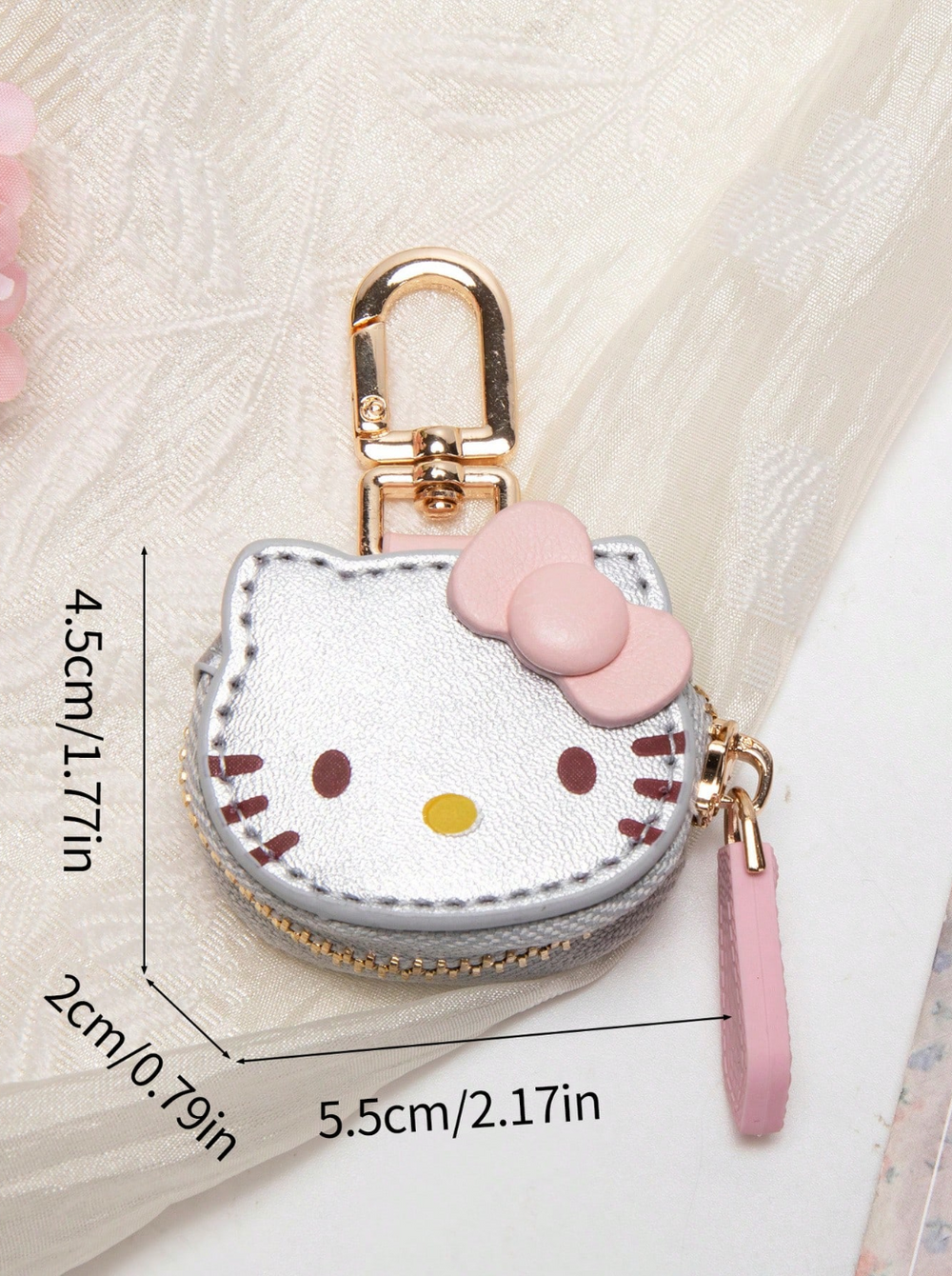 A white and pink Hello Kitty-themed coin purse with a gold-tone metal zipper pull and keychain attachment.