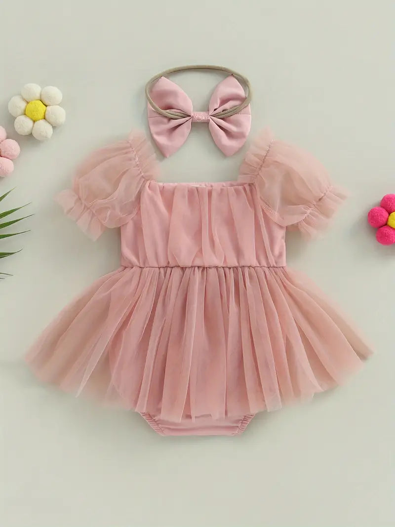Pale pink baby romper with puffy tulle sleeves and a large bow headband.