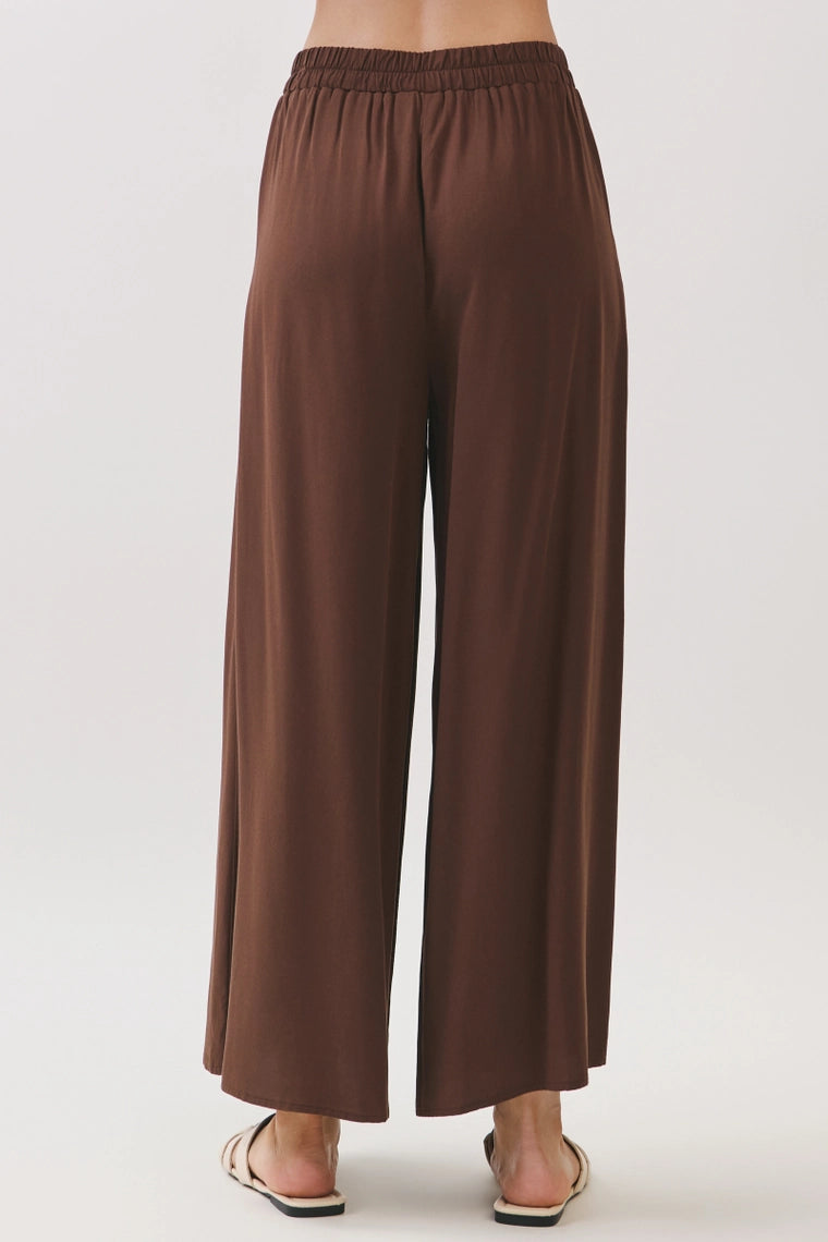 Brown wide leg pants with elastic waistband, back view.