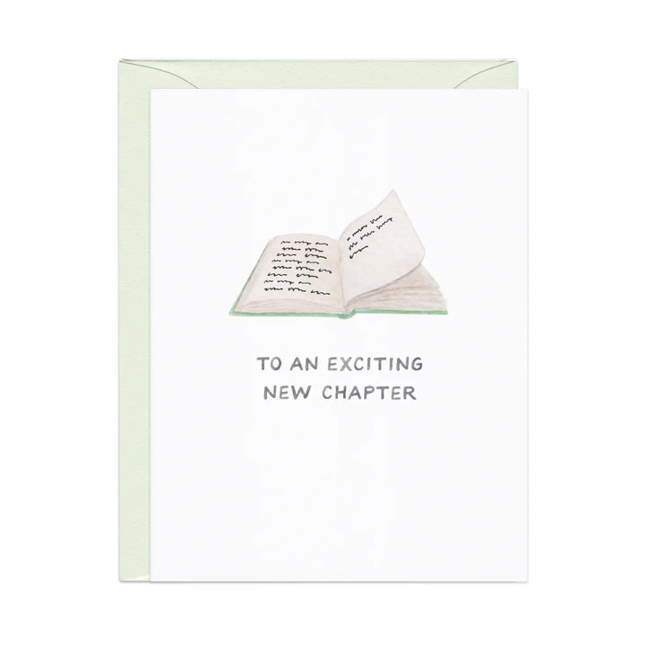 White greeting card with a simple illustration of an open book and text reading "TO AN EXCITING NEW CHAPTER".