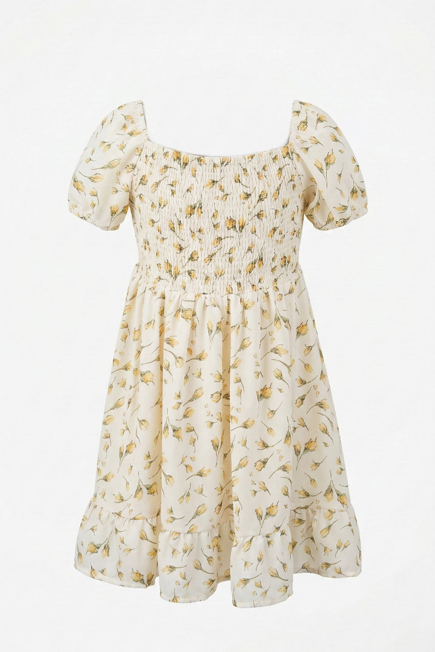 A white dress with a floral print, featuring puff sleeves, a fitted bodice, and a flowing, smocked skirt.