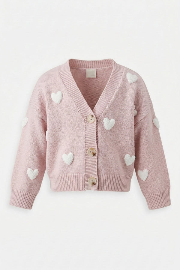 A cozy, pale pink knitted cardigan for girls, featuring white heart-shaped appliques and button-up closure.