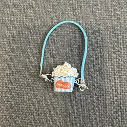 A turquoise metal wire hoop attached to a charm featuring a white cloud with an orange sun and the Labubu logo.