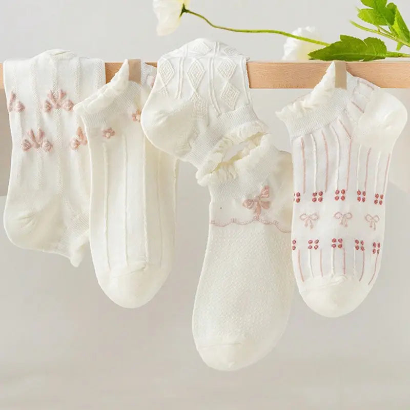White cotton ankle socks with floral and bow embroidery and delicate ruffle trim.